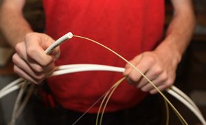 Närbild på en tekniker som håller upp en fiberkabel